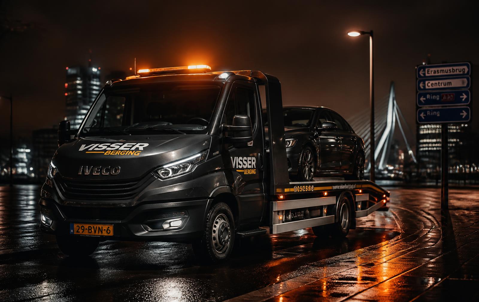 Takelwagen met auto op de laadbak in de nacht